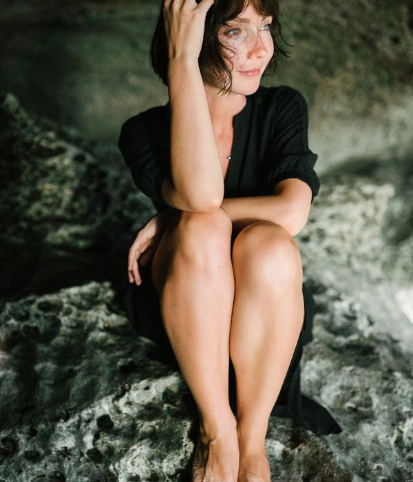 Person sitting in a meditative yoga pose with a calm and serene expression.